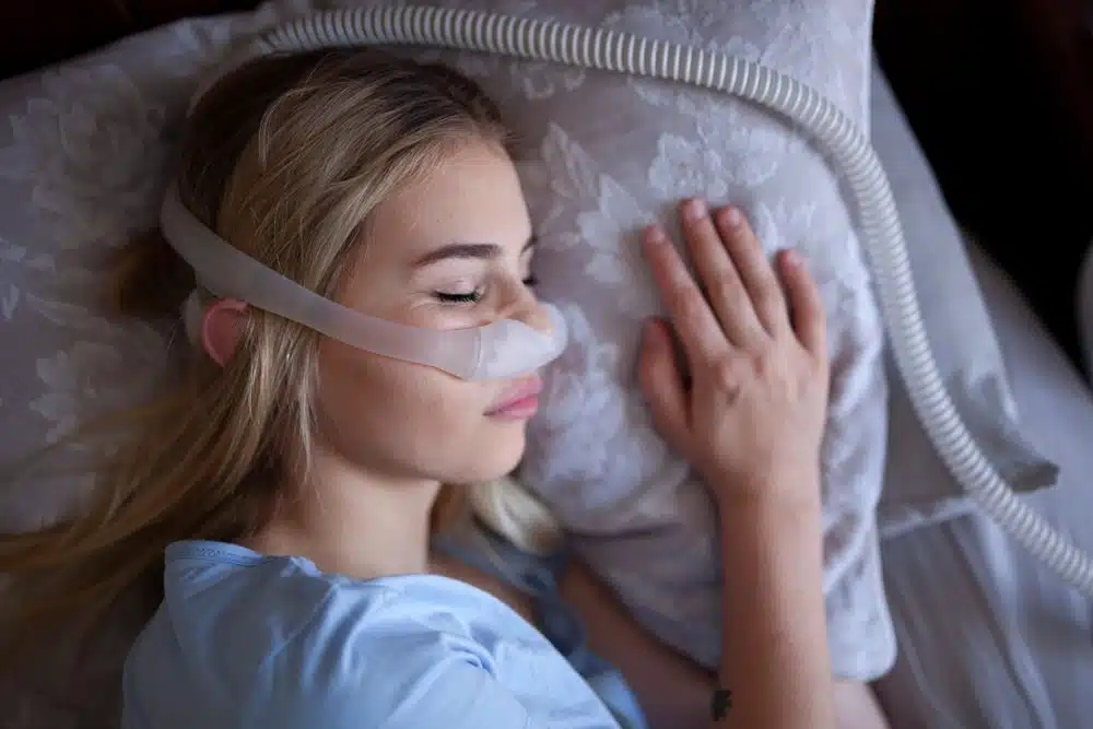 Cpap machine, women using for treatment of sleep apnea