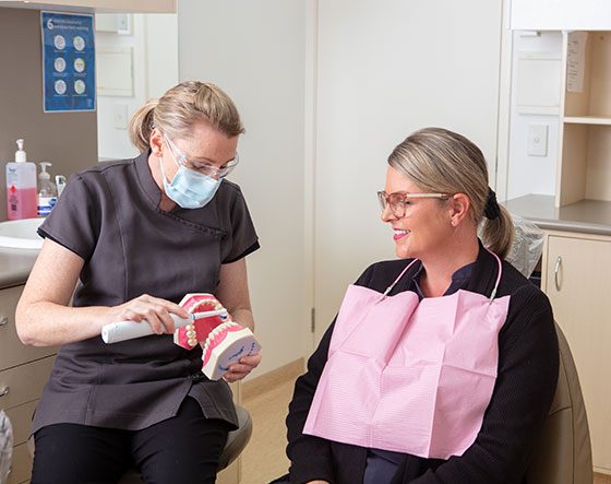 Dentist Showing Patient Dental Hygiene — Suncoastdental In Maroochydore, QLD