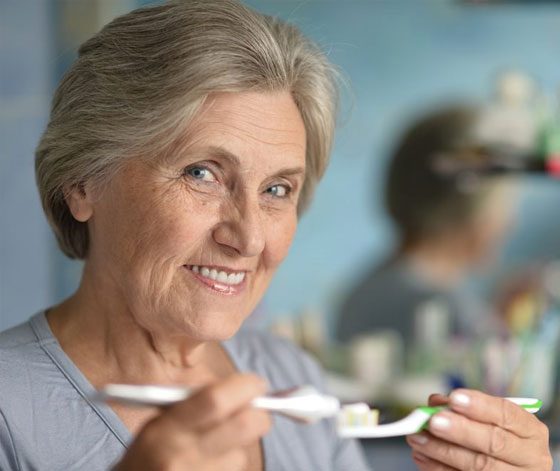 Old Woman Taking Care Of Her Dentures — Suncoastdental In Maroochydore, QLD